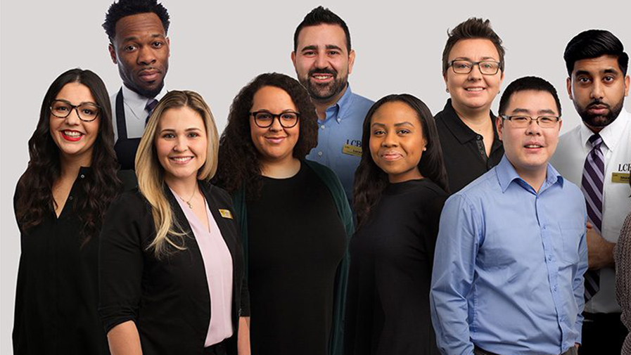 Photo of 14 smiling diverse employees from all areas of the business